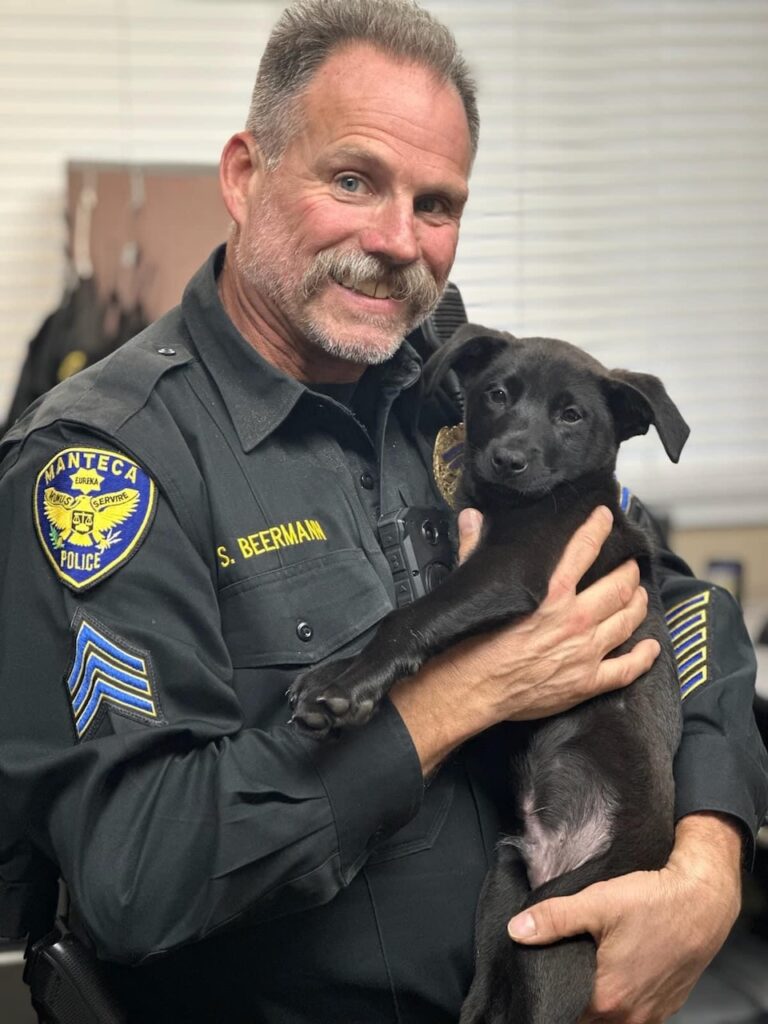 Officer Beerman holds his newly adopted dog Puck